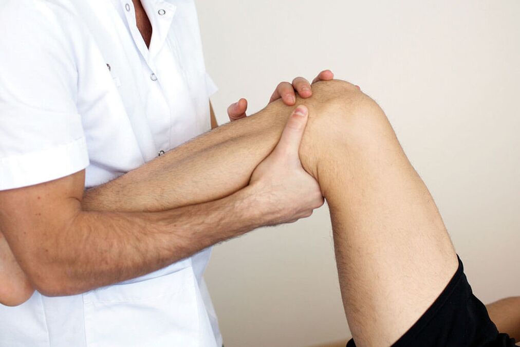 Doctorul examinează un genunchi cu osteoartrită